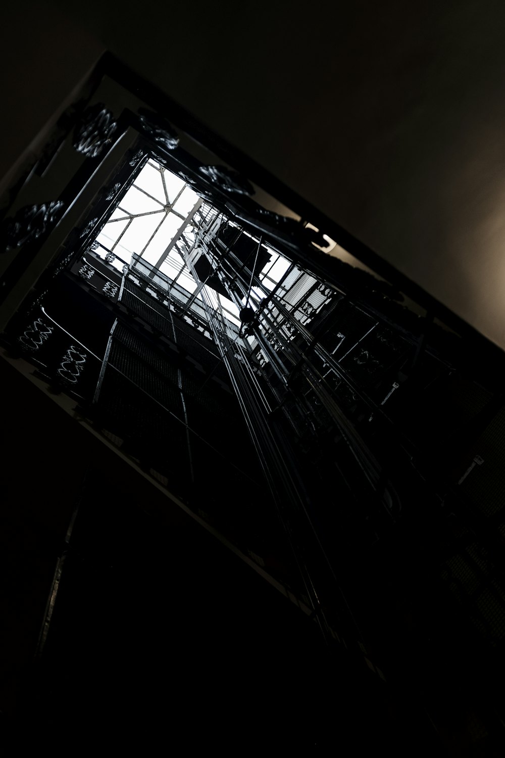 Looking up a lift shaft with cables and guide rails