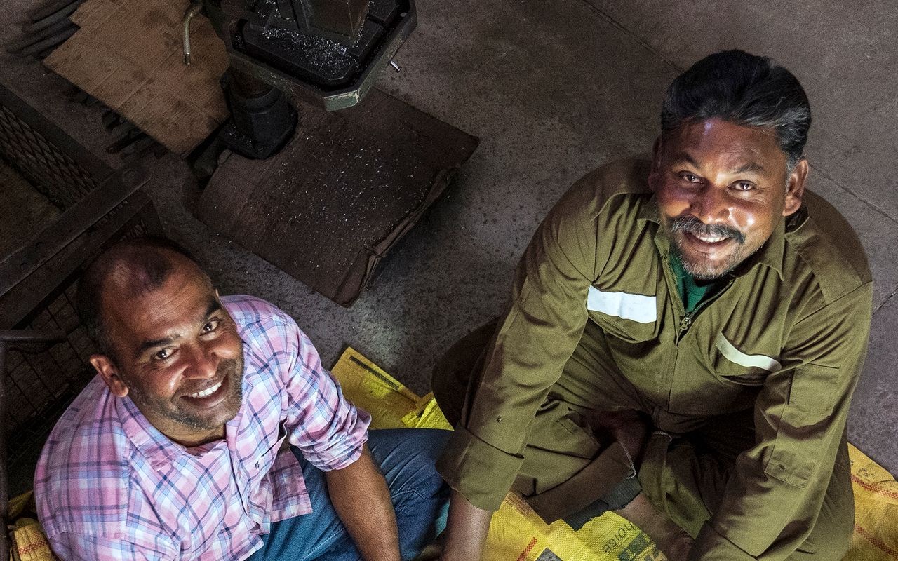 Two smiling technicians working together in a workshop